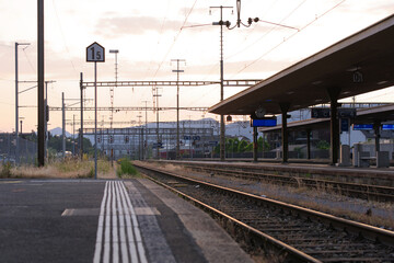 Fototapeta premium Dramatic sky with sunset at Lenzburg railway station on a late spring evening. Photo taken June 7th, 2023, Lenzburg, Switzerland.