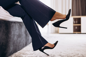 Female legs wearing high heels in hotel room close up photo