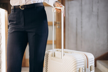 Business woman with travel luggage at the hotel - obrazy, fototapety, plakaty