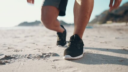 Feet, runner and tie shoes at beach for running, workout and fitness performance. Closeup, hands and athlete lace sneakers, footwear and prepare on sand at sea for exercise, sports or summer training