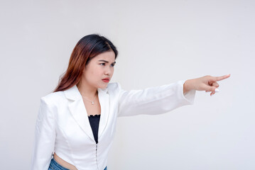 An irked and irritable young woman glaring and pointing to the right. Isolated on a white background. - obrazy, fototapety, plakaty
