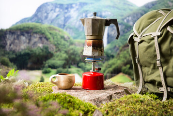 Cooking, making coffee or tea on a portable camping gas burner with a red gas cylinder with a...