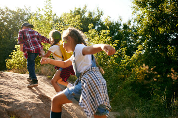 Little boys and girls, children having fun outdoors in forest, going hiking together, enjoying active weekends. Leisure activity, childhood, summer, friendship, active lifestyle, fun, nature concept