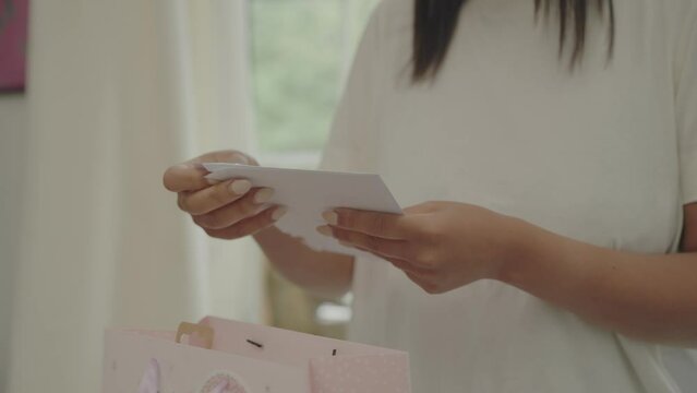 Woman looking at greeting card for her baby daughter
