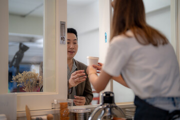The Barista woman worker is serving a cup of coffee to customer at the counter pantry of the cafe....