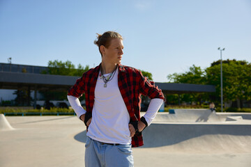 Portrait of fashioned teenager sportsman looking aside over rollerdrom