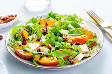 Grilled Peach Salad with Blue Cheese, Pecans and Arugula on Bright Light Blue Background