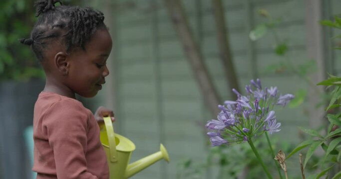 Girl watering flowers in garden