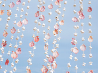 seashells mobile hanging for curtain against blue sky background - 638372221