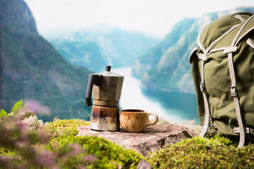 Morning coffee with a Moka coffee maker and a traditional wooden Finnish cup Kuksa in a tourist camp against the backdrop of a Scandinavian landscape