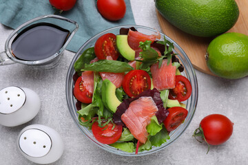 Soy sauce, salad and ingredients on grey table, flat lay