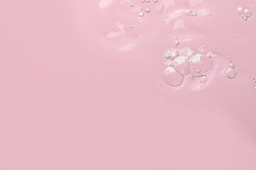 Transparent cleansing gel on pink background, top view with space for text. Cosmetic product