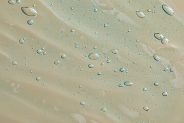 Transparent cleansing gel on beige background, top view. Cosmetic product