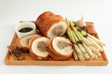 bbq roasted pork meat roll stuffed with spices ingredients onion with chef brown sauce in wood board on white background appetiser Christmas festival party halal food hotel cuisine restaurant menu