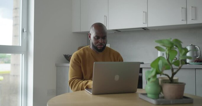 Man using laptop while working in kitchen