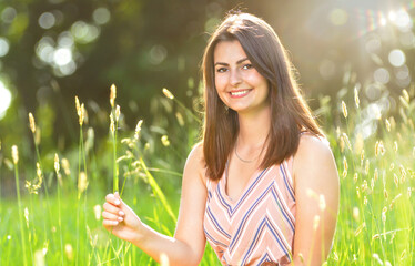 Young woman sits contentedly on a meadow