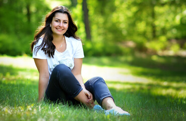 Young woman is sitting relaxed on a meadow