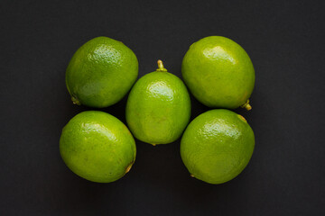 Five (5) Green Limes on black background