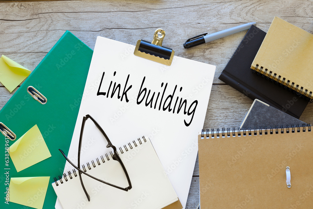 Poster link building text on white a4 paper. green folder
