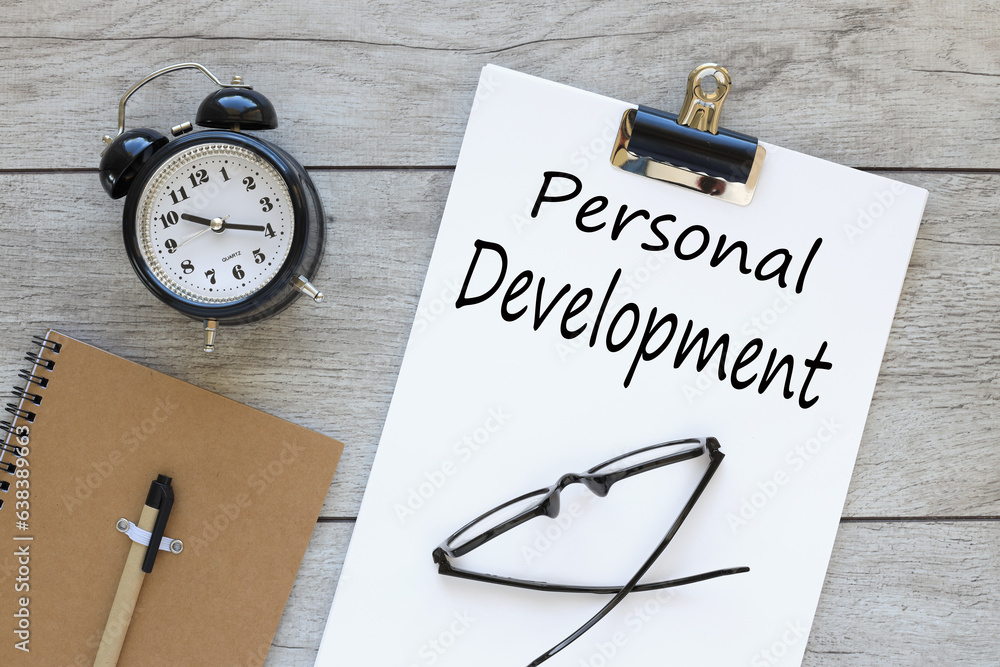 Poster personal development text on white a4 paper. desktop clock and sticker beautiful notepad