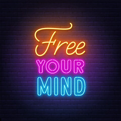 Free Your Mind neon lettering on brick wall background.