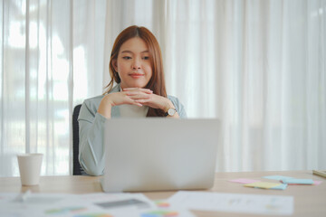 Beautiful Asian business woman working on laptop and her paperwork in the office.