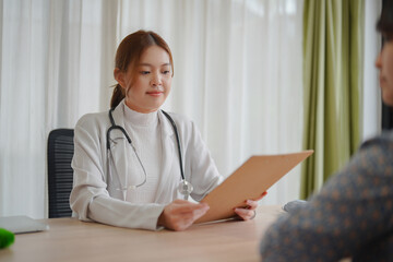 Asian woman doctor gives consultation to woman patient to suggest treatment and guideline and healthcare concept in medical office.