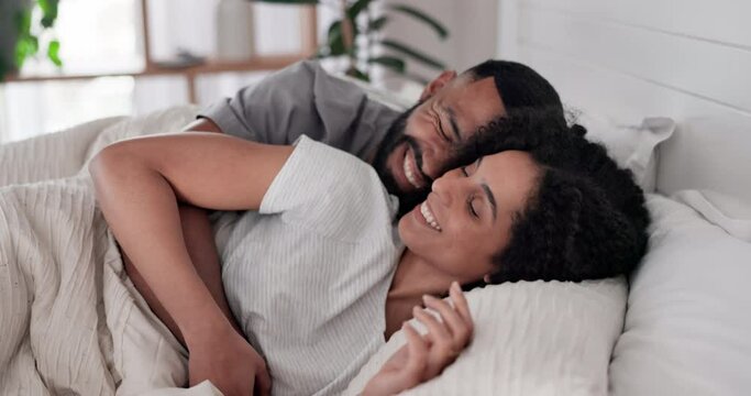 Happy, relax and couple hug in bed with care, conversation and resting in their home together. Waking up, love and happy man with woman in a bedroom cuddle, romantic and lying, speaking and smile