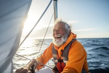 Fototapeten Happy senior man sailing on a yacht in the sea at sunset. © Nerea