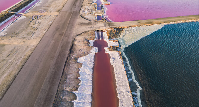 Aerial view of pink salt lake. Salt production plants evaporated brine pond in a salt lake. Salin de Giraud saltworks in the Camargue in Provence, South of France