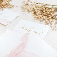 calligraphy thank you text on a white paper written in gold ink