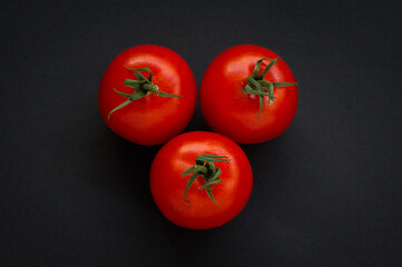 Three Red Tomatoes on black background