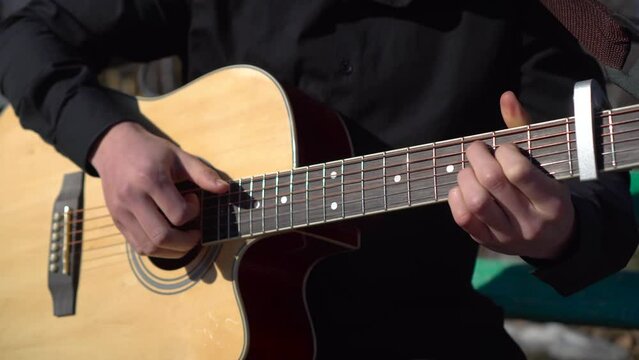A young man plays the acoustic guitar. 