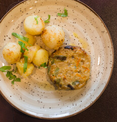 Squash burger with boiled potatoes on a plate. top view