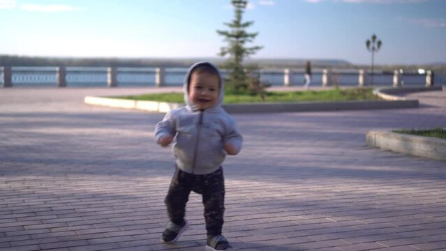 A one-year-old son runs along the paving stones