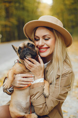 Portrait of a young blonde girl with a little puppy french bulldog