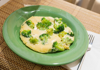 wholesome breakfast. omelet with broccoli on green plate