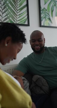 Pregnant couple talking while sitting in living room