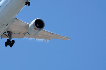 Detail of an approaching plane against a blue sky