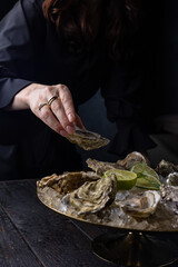 large, beautiful, fresh oysters on a dark table. Close up