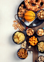 Snacks on white table with basketball ball, game night food.