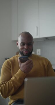 Man talking by phone while working in kitchen