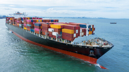 Aerial side view of  cargo container ship carrying container from custom container depot go to ocean concept freight shipping by ship service on blue sky .Freight Forwarding