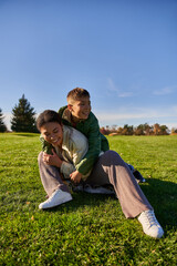 Fototapeta premium happy mother and son in park, sunny day, autumn, playful african american boy hugging mom, diversity