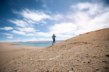 Woman trail runner cross country running at lakeside
