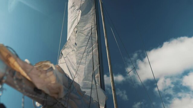 Main sail on a sailing boat being hoisted, raising the sail on a yacht, boating video