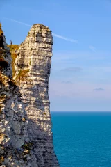 Fototapeten Calm coast with rocky cliff, blue ocean, and serene horizon over water. at etrata, france © Ridder