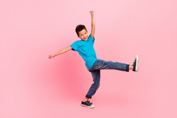Full length photo of pretty excited little boy dressed blue t-shirt walking dancing isolated pink...