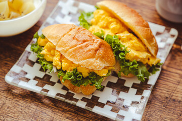 スクランブルエッグサンドとゴールドキウイのヨーグルトサラダの朝食