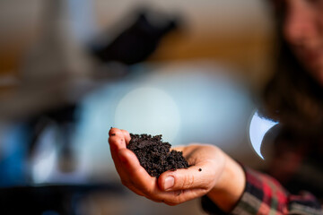 female scientist holding mineral soil in a laboratory